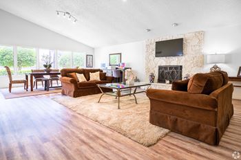 a living room with two brown couches and a fireplace with a tv above it